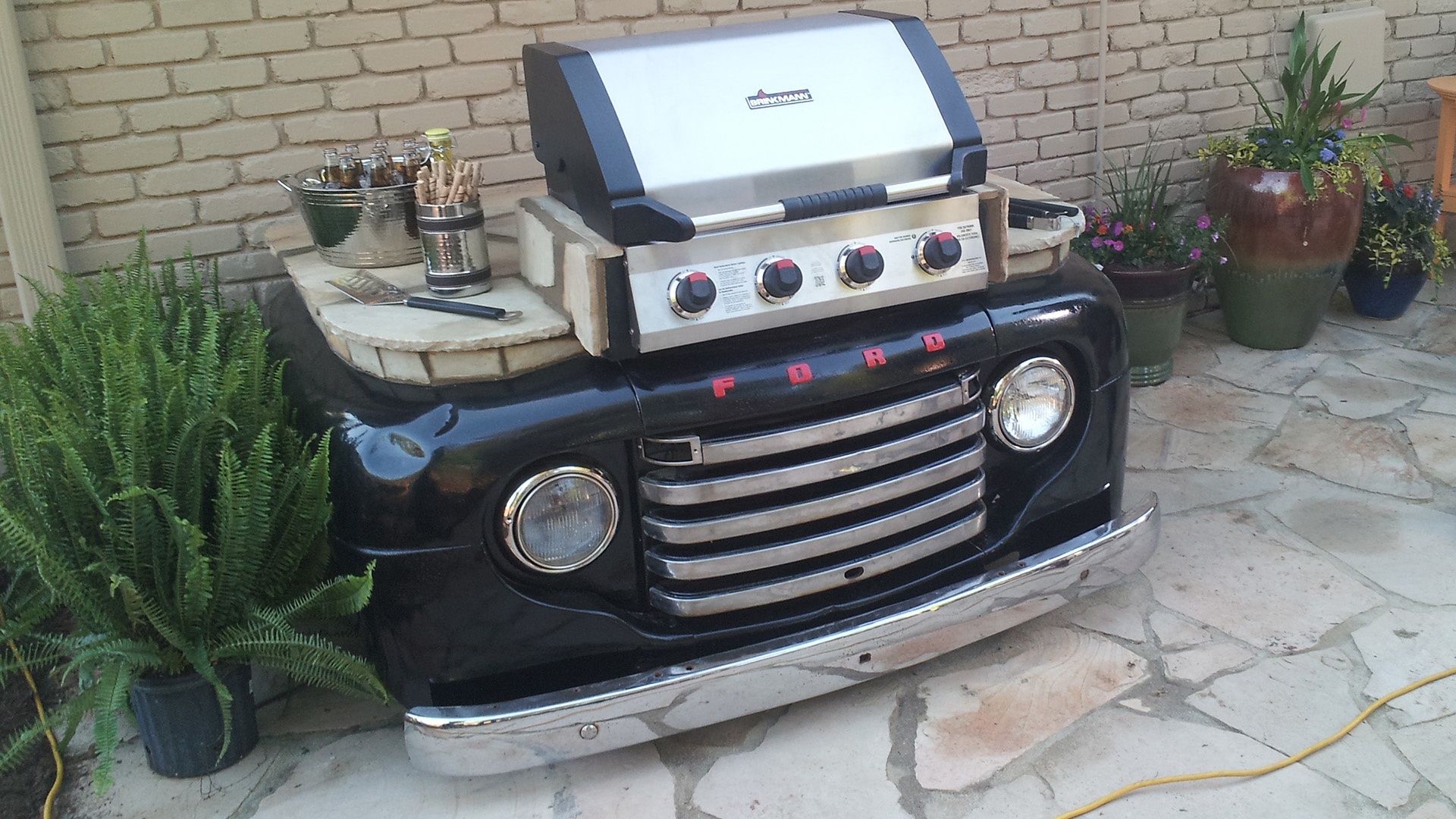 Residential landscaping. Outdoor kitchen with retro car front end