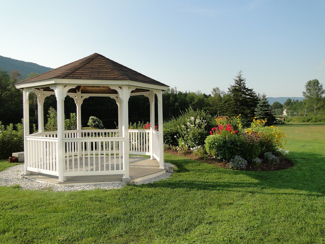 White gazebo in garden with mountain view