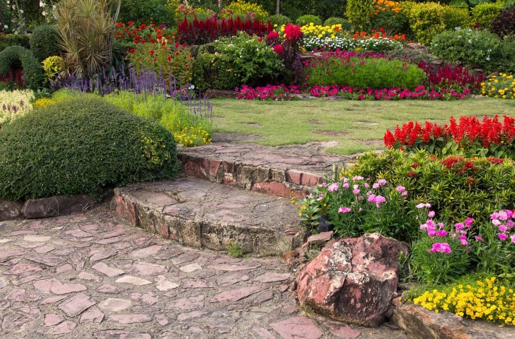 A lush flower garden with stone steps and vibrant plants.