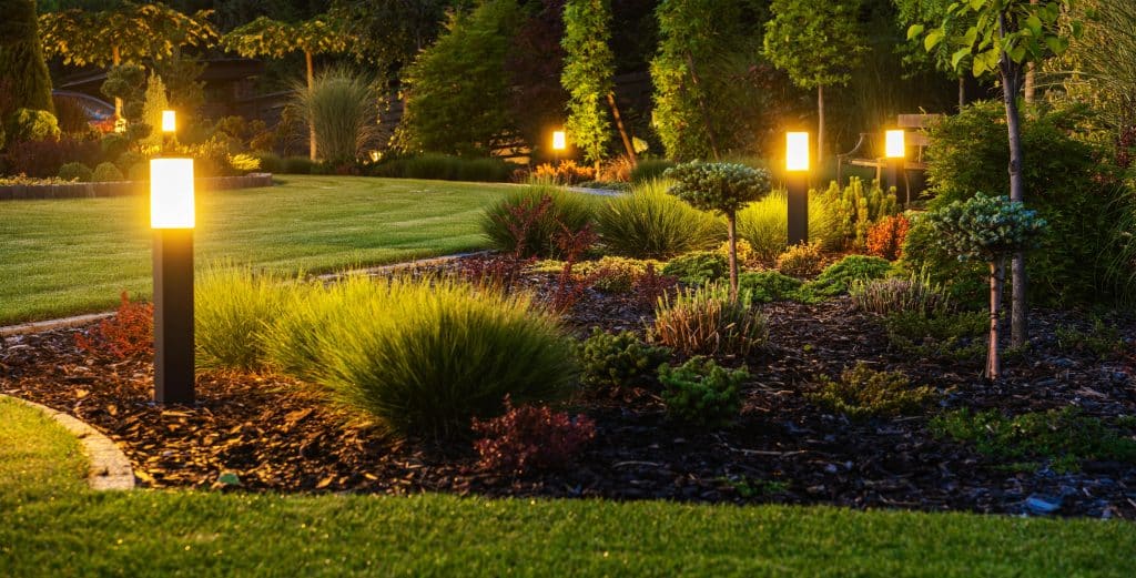 Illuminated garden path with glowing bollard lights.